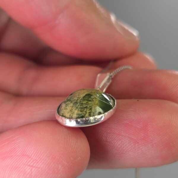 Pendant, silver, pounamu, flower jade, taonga. (4) Pendant, silver, pounamu, flower jade, taonga. (4)