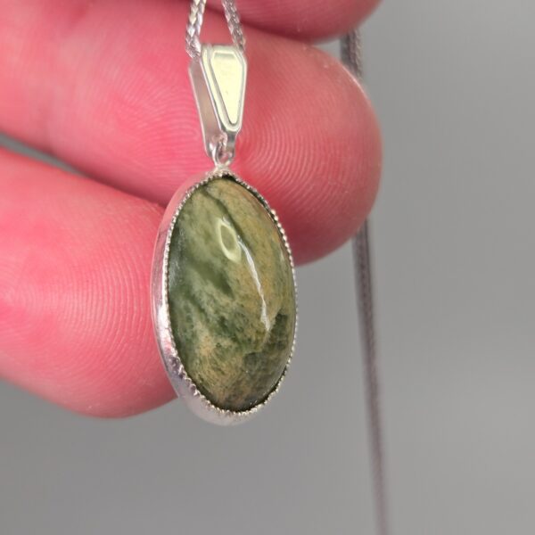 Pendant, silver, pounamu, flower jade, taonga. (8) Pendant, silver, pounamu, flower jade, taonga. (8)